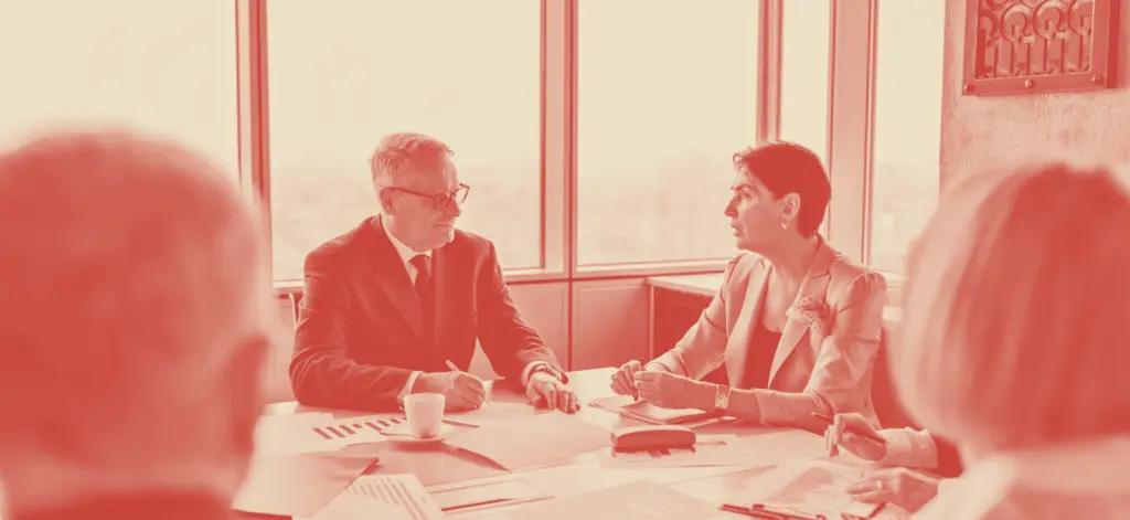 business people sitting around large table planning the future